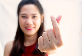 Asian beautiful woman make mini heart gesturing  and express happiness and smiling for valentine's day. Love concept. A Close up heart hand shape gesture.