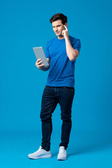 Young handsome Caucasian man holding tablet computer and pointing finger on head in isolated a...