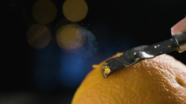 Macro Shot Peeling citrus orange, oil particles being release in Slow motion, Blurred Background