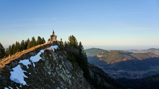 Golden hour timelapse of the Freudenreich chapel on the ridge of Brecherspitz, a famous hiking destination in the mountains of the alps in Bavaria, Germany