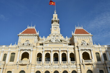 Fototapeta na wymiar Low Angle Center Facade Detail of People's Committee of Ho Chi Minh City with Flag in Bright Morning Light