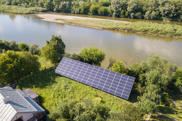 Aerial view of blue photovoltaic solar panels mounted on backyard ground for producing clean ecological electricity. Production of renewable energy concept