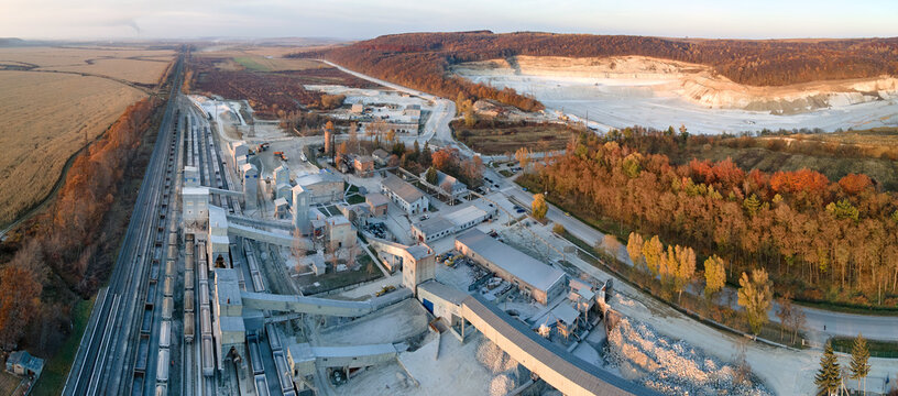 Aerial view of cargo train loaded with crushed sandstone materials at mine factory. Railway transportation of open pit mining ore