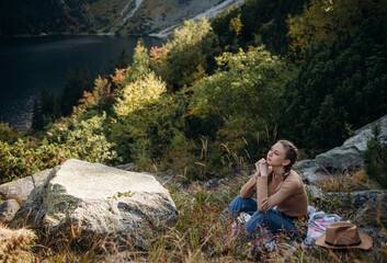 Young woman on a hiking trip sitting on a rock