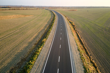 Aerial view of empty intercity road at sunset. Top view from drone of highway in evening