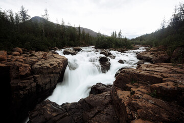 Obraz premium The waterfalls of the mountain river on a cloudy day. Plateau putorana