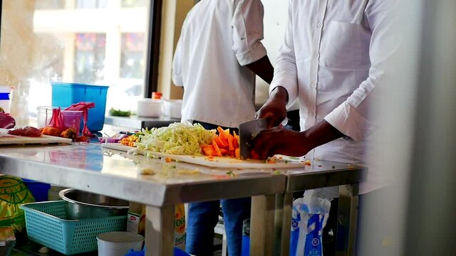 African American Chef Chopping Vegetables on a White Board