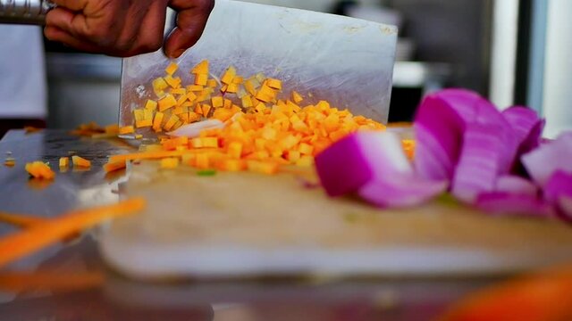 Chef Chopping Carrots on a White Chopping Board