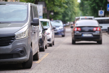 Fototapeta premium City traffic with cars parked in line on street side