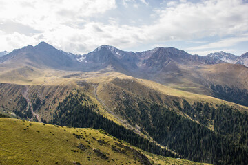 Beautiful Summer landscape: blue cloudy sky, green hills and distant mountains