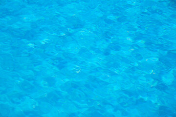 Closeup surface of blue clear water with small ripple waves in swimming pool