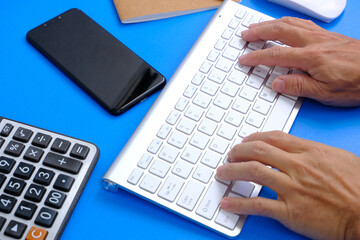 Man hands working on modern laptop. Office desktop and using smartphone 