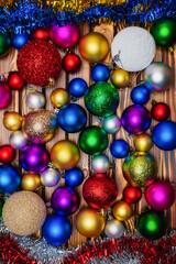 Fototapeta na wymiar Group of Christmas balls spheres and tinsel on wooden table background. Closeup view of Happy New Year holiday decoration. Table top of festive composition for Xmas.