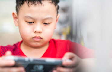 boy sit down and play portable game console