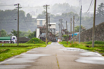 砂の分別する工場へと向かう長い道、雨上がりの霧に包まれて。