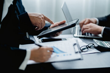 Close up of businessmen groups using digital tablet and laptop working analyzing business reports at the workplace, Business people discussing plan new project, chart, graph, marketing and financial