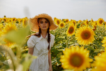 woman with two pigtails looking in the sunflower field Summer time