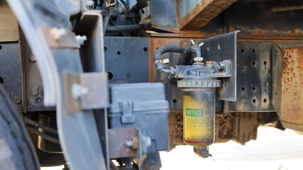 Obraz premium fuel filter truck. Old clear plastic water trap in the fuel system mounted on the side of the truck with copy space. Auto parts concept. Close focus and select an object