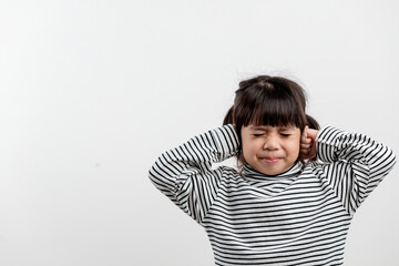 Cute asian kid girl covered ears the fingers and gesturing that not want to listen on white background with empty copy space