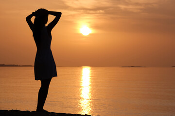 Young woman relaxing alone on ocean sand shore by seaside enjoying warm tropical evening