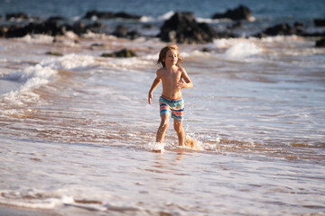 Child boy on the coast. Little kid playing in the ocean. Holidays on the sea. The child in waves.