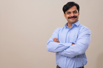Man in formal dress posing in front of camera with folding hands