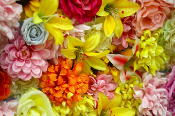Fototapeta na wymiar Many colored artificial flower tapestry wall design