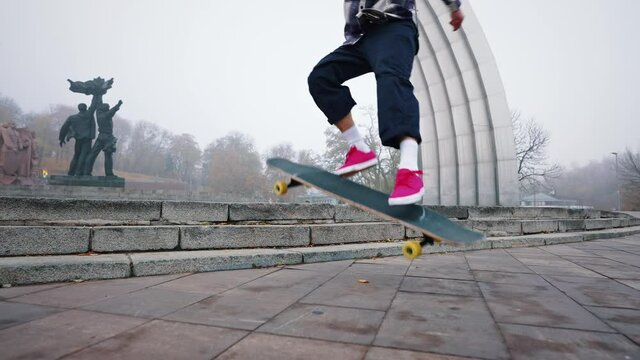 Falling from a skateboard outside, bad trick, skater error, slow motion. Skateboarder jumping stairs in the street. Jump and flip. A young guy demonstrates his boarding skills