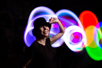 A woman in the dark in a multicolored light. The concept of energy, aura.