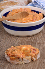 Ktipiti dans un ramequin avec une cuillère en bois à côté d'une tartine de pain en gros plan