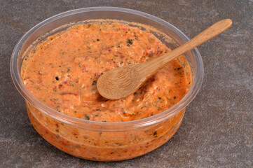 Ktipiti dans son emballage avec une cuillère en bois en gros plan sur fond gris