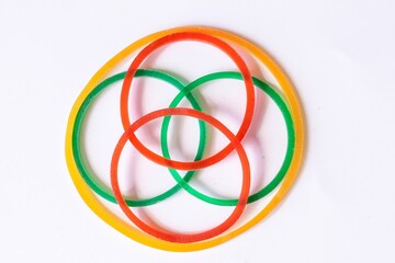 Circle rubber bands in a variety of bright colors on a white background.