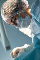 Close-up of a female surgeon in an operating room, a doctor with a tense expression on his face, in an operating room.
