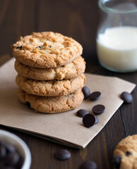 Composition with cookies, milk and chocolate drops on a wooden table. Delicious cookies with chocolate. An idea for breakfast or a snack. Selective focus