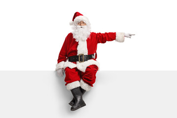 Santa claus sitting on a blank white banner and pointing to the side - Powered by Adobe