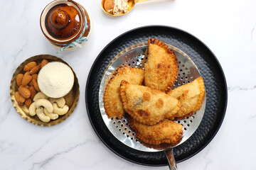 Indian Holi snack popuraly known as Gujia or Gujiya. Also called Karanji in Maharashtra, mostly eaten during Diwali. It is a deep fried sweet dish made from maida and stuffed with khoya or rava. copy.