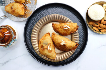 Indian Holi snack popuraly known as Gujia or Gujiya. Also called Karanji in Maharashtra, mostly eaten during Diwali. It is a deep fried sweet dish made from maida and stuffed with khoya or rava. copy.