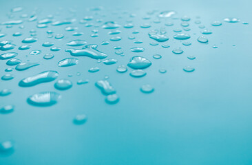 splashes of water drops on a blue background. A round drop of water. Drops, splashes, splashes, abstract figures from the water.