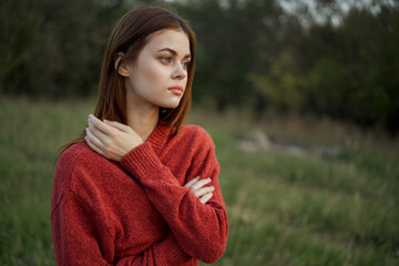 woman in a red sweater outdoors in a field walk