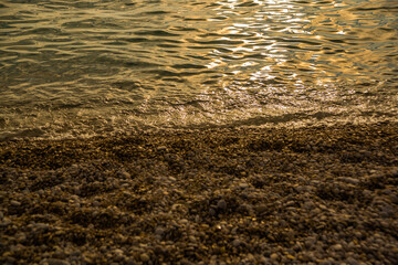 OLUDENIZ, TURKEY: Sea waves and small rocks on Oludeniz beach in the evening.