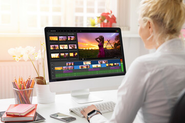 Woman editing video on desktop computer - obrazy, fototapety, plakaty