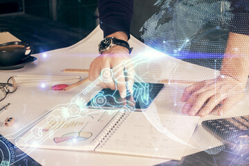 Double exposure of man's hands holding and using a digital device and tech theme hologram drawing....