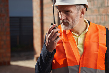 Focused construction expert having a conversation on the radio