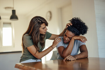 Sad african-american woman, getting help from her friend