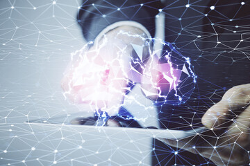 Double exposure of man's hand holding and using a digital device and brain hologram drawing. Data concept.