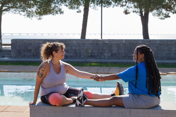 Friendly plus size women resting doing sports outdoors. Chubby women of different nationalities in...