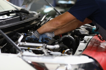 Fototapeta na wymiar Professional mechanic male repair detail in automobile on pit station