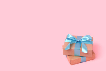 Pile of gift boxes in front of pink background. Present with blue tied ribbon. Congratulation concept with copyspace.