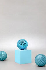 Blue Christmas baubles in front of silver colored background.
