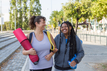 Cheerful plus size women going home after training. Chubby women of different nationalities in...
